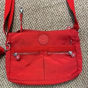 Kipling shoulder bag red 2 front side pockets and inside zipper pocket.